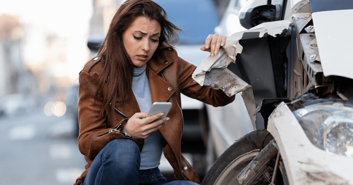 Woman holding her phone on her hand after a car accident